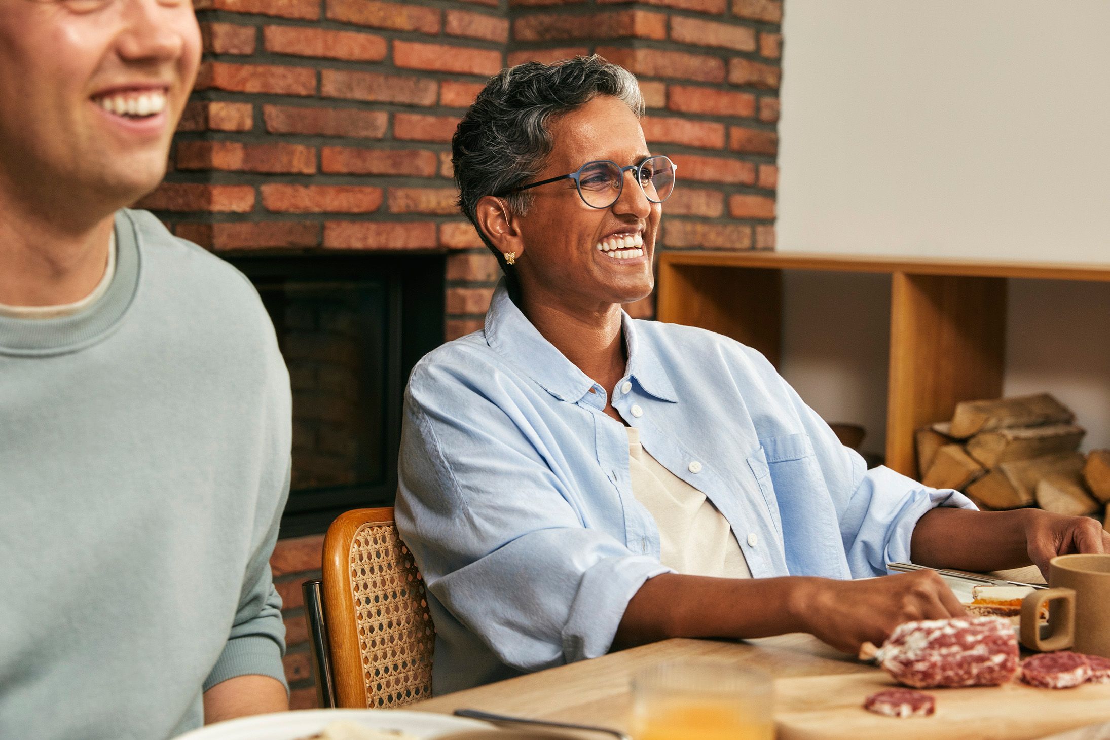 Smilende dame og mann sittende rundt et frokostbord